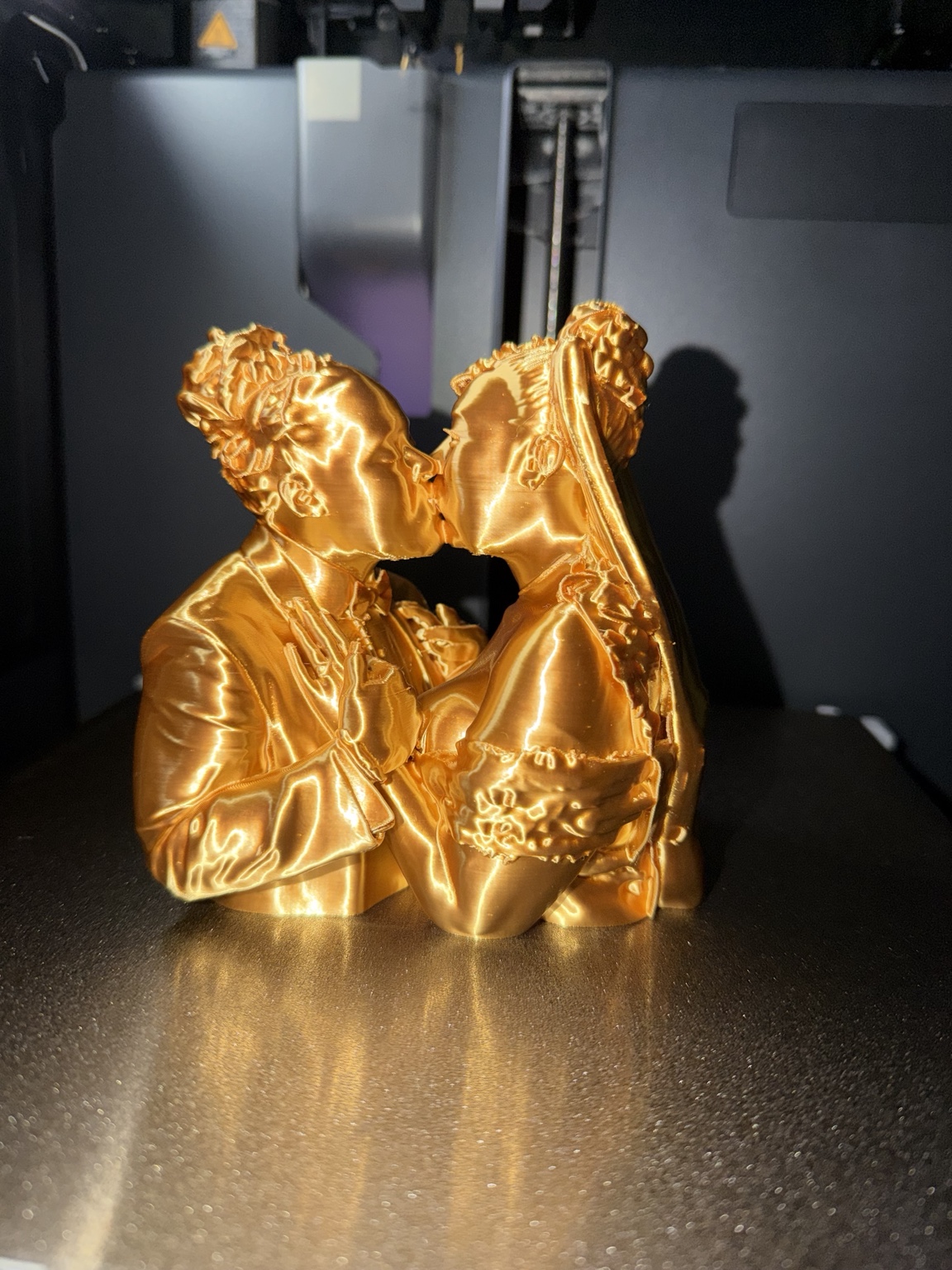 Gold 3D printed couple sculpture on printer